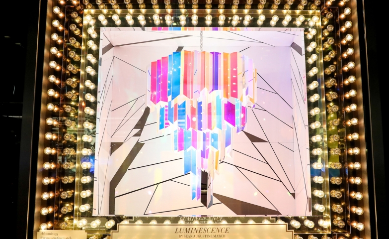 An abstract way to create a Christmas window display, with many lights bulbs, and in the middle some geometric shapes with colors with the theme of Luminescence.