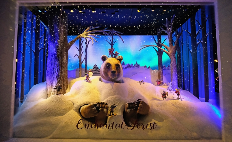 A big bear sunk in snow, a cute theme for a Christmas window display.