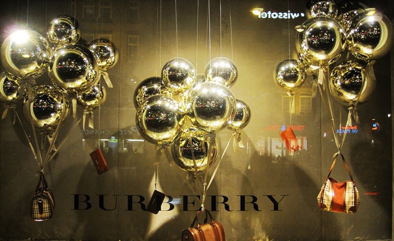 Burberry has three sets of golden balloons for Christmas window display, all of them carrying a purse.