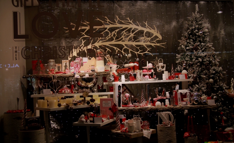 You cannot be bored with candles and so many red objects, a snowed fir and Christmas lights all in this window display.