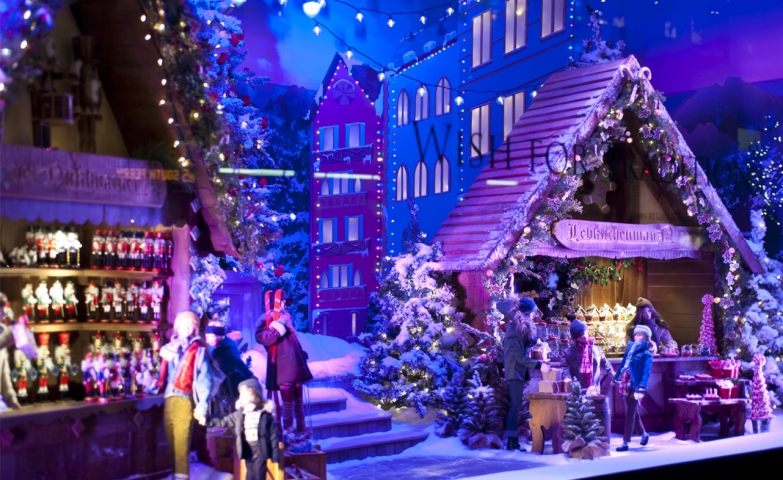 This Christmas window display is including little houses, little waxworks, and all together are creating the image of a marketplace in the holiday time.
