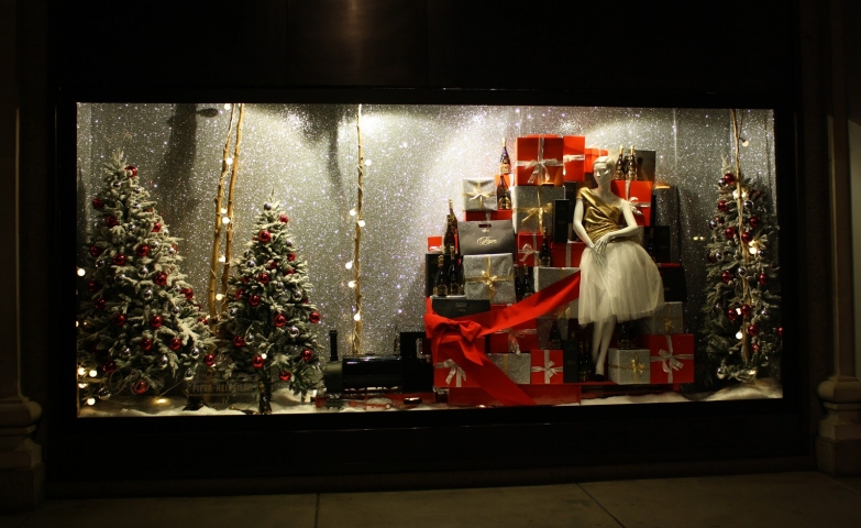 Let’s get into the Christmas spirit with this beautifully wrapped presents and firs adorned with red spheres, like in this window display.